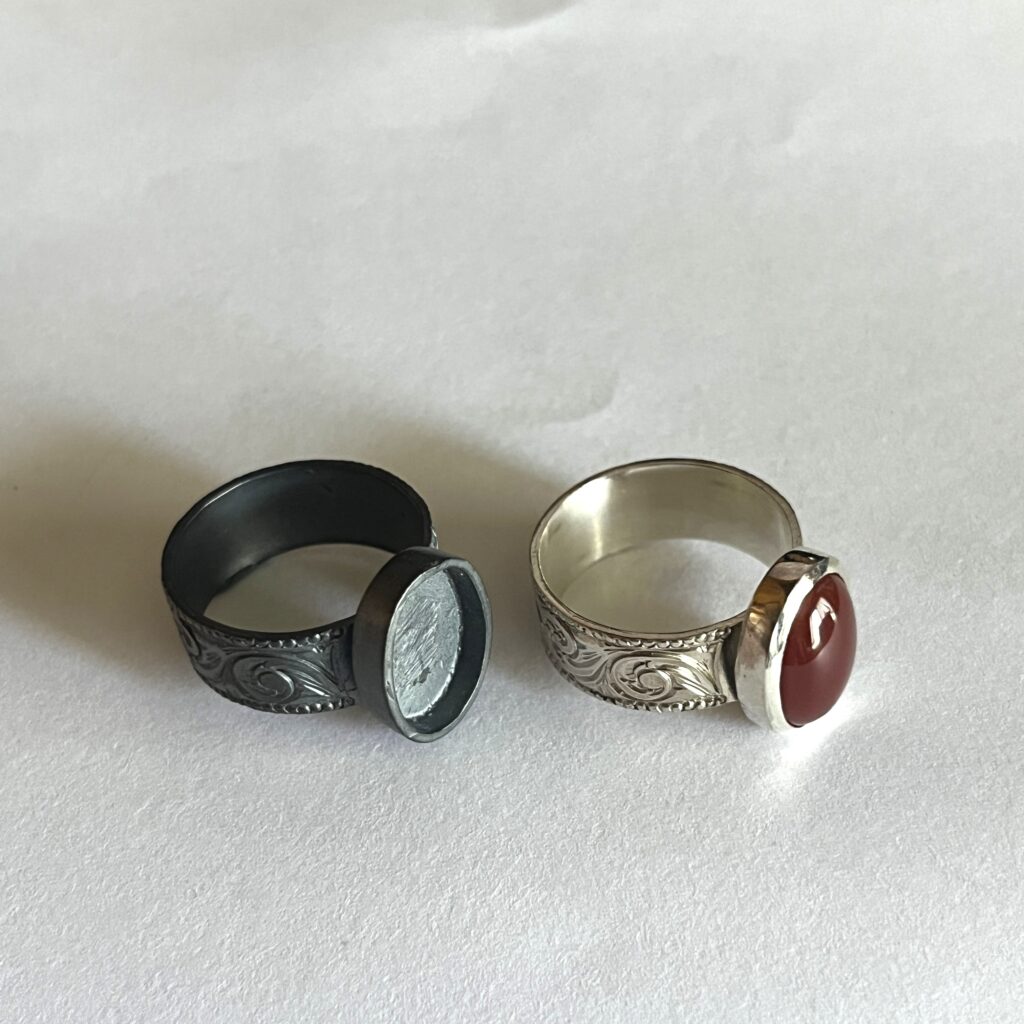 銀黒で燻したシルバーリング（左）と、燻し液を使わずカーネリアンを石留めしたシルバーリング（右）の比較画像。燻し仕上げによる色合いの違いや、銀黒によるアンティーク調の風合いを紹介するための参考写真。