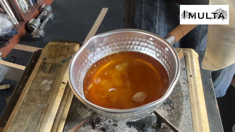 彫金で金属を固定するための松脂を鍋で加熱し、完全に溶けて液状になった状態。次の工程で地の粉を加えて硬さを調整する準備をしている