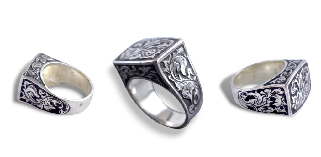 四角い形状のシルバーリングを三方向から撮影した画像。手彫りの唐草模様が正面・側面に刻まれており、燻し加工で陰影が強調されている