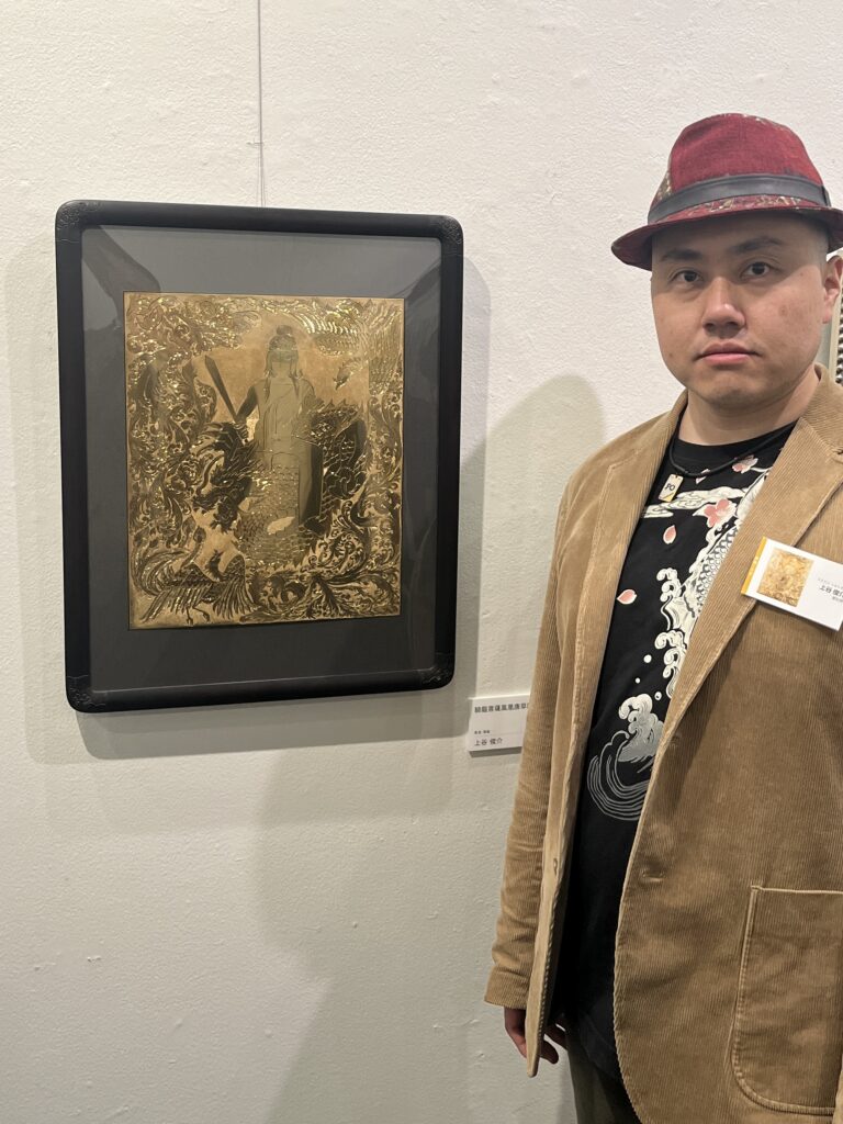 選抜作家展での展示作品と彫金師の上谷俊介が写っている。
